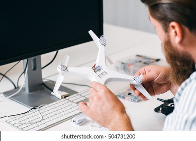 Drone Testing In Toy Repair Shop. Engineer Checking All Connections And Battery Of New Unmanned Aerial Vehicle. Technology, Innovation, Electronics Concept