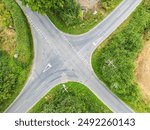 Drone top down view of a dangerous British crossroads seen in a rural location. A nearby blin bend makes this crossing hazardous.