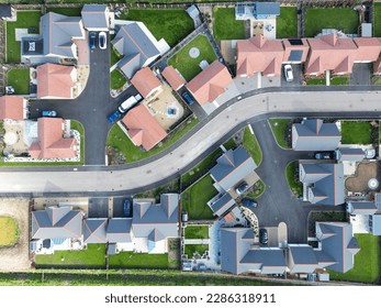 Drone top down view of detached bungalows seen at a new housing development in the English countryside.