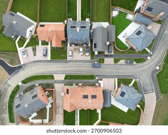 Drone tops down view of the abstract design of a newly completed housing development site in rural Britain. Note the lush, newly laid lawns.
