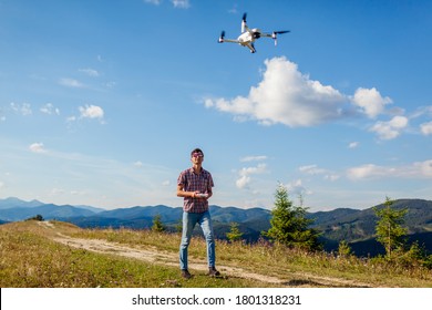 Drone video shooting of summer Carpathians. Man operating copter controller in mountains. Tourist filming nature
