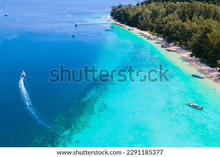 drone view at the beach of Koh Kradan island in Thailand, aerial view over Koh Kradan Island Trang with longtail boats in the ocean