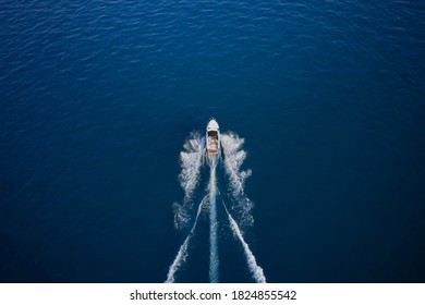 Drone view of a boat sailing across the blue clear waters. Aerial view of luxury floating ship at sunset, blue sea. High altitude air view. Yacht at the sea in Europe. - Powered by Shutterstock