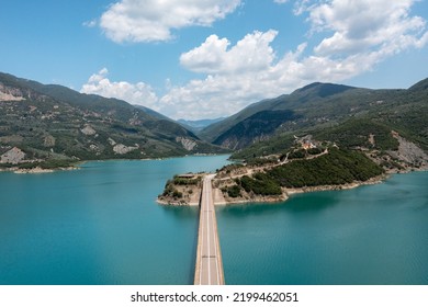 Drone view of bridge over blue lake with mountains at background. Central Greece - Shutterstock ID 2199462051
