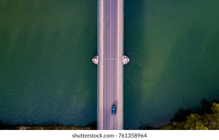 Drone View Of A Bridge With A Single Car Crossing The River