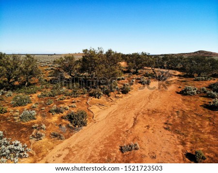 Drone view of a dry watercourse through Pearl Bluebush Plains in outback Australia