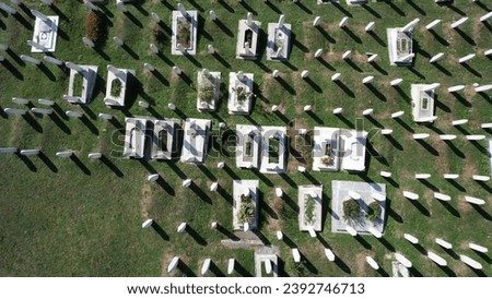 Drone view of the historical mausoleum built by the Bosnian people for those who died in the war, white graves of the muslim graveyard on the hill above Bosnia and Herzegovina