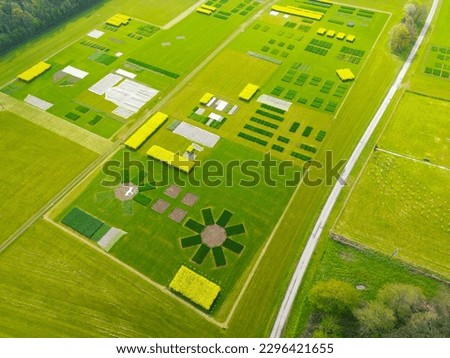 Drone view of a large experimental crop field showing the abstract shapes from the air. The crops are grouped to be tested in closed conditions.