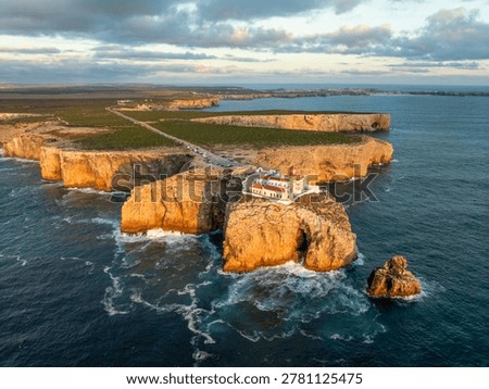 Drone view of the Lighthouse of Cabo de Sao Vicente in Sagres, Algarve, Portugal, at sunset with cliff edge and Atlantic ocean