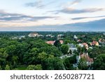 Drone view of lush suburban neighborhood with iconic Centennial Hall under cloudy summer sky