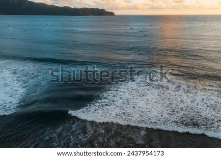 Drone view of ocean rip current, beach with waves in Java at sunset