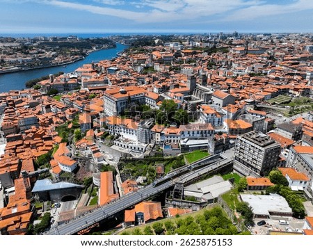 Drone view of Porto’s old town with elevated metro crossing Dom Luís Bridge