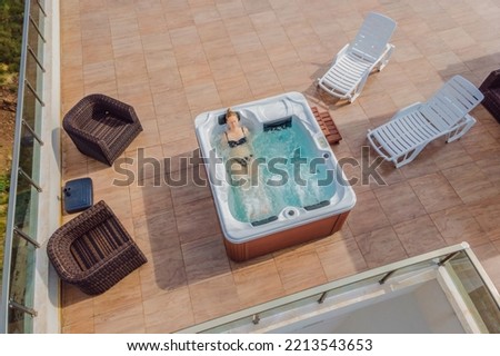 Drone view. Portrait of young carefree happy smiling woman relaxing at hot tub during enjoying happy traveling moment vacation life against the background of green big mountains