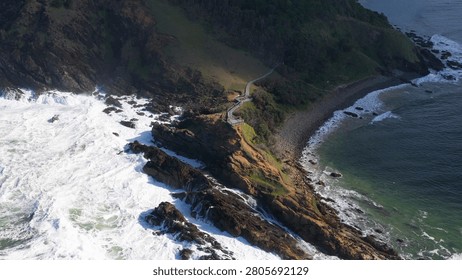Drone view of powerful ocean waves hitting a rocky Australian headland.