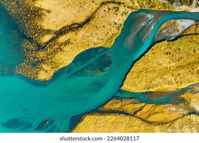 A drone view of the river on the field. An aerial view of an autumn landscape. Winding river among the meadows. Turquoise mountain water. Landscape with soft light before sunset.  - Shutterstock ID 2264028117