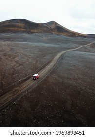 Drone view of a Suzuki Jimny driving on a dirt road