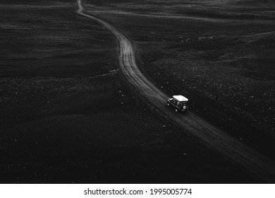 Drone view of a Suzuki Jimny driving on a dirt road