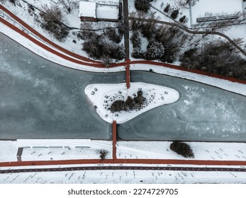 Drone Winter Footage. Frozen Lake In The City Center With An Island In The Middle With Trees. Cinematic Drone Winter Footage. Snow, Ice, Frozen Lake, Clouds. Houses And Streets. - Shutterstock ID 2274729705