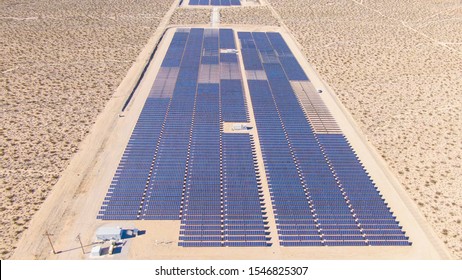 DRONE:Flying Above Long Rows Of Photovoltaic Panels Installed In A Remote Part Of United States. Barren Landscape Surrounds A Large Farm Of Solar Panels In California. Solar Cells In The Desert.