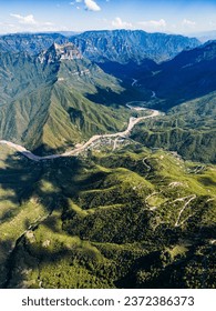 Desde el ojo de un dron, el panorama aéreo del cañón de Urique dentro del Cañón del Cobre, Chihuahua, revela un sinuoso camino que conduce a la enclavada aldea de Urique, retratando una narrativa escénica de remoto encanto