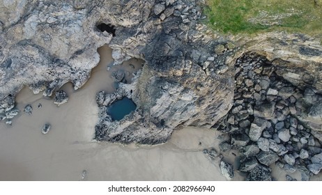 A drone's eye view of the large natural rockpool that gives its name to Blue Pool Bay on the Gower Peninsula in Swansea, UK