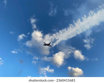 Drones and fighter jets performing a demonstration flight. In the blue sky