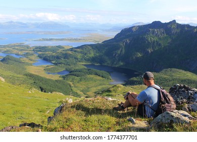 Dronningruta hike - popular route in Norway. A tourist with a backpack sits and admires the landscape.
