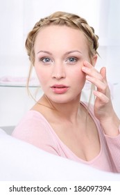 Drooping Eyelid. Portrait Of A Woman Examining Themselves In A Mirror.