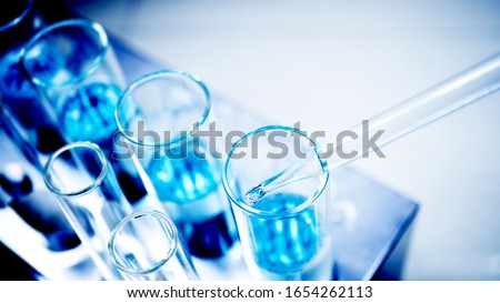 drop blue liquid and droplet laboratory for science test , lab chemical study and medical concept background