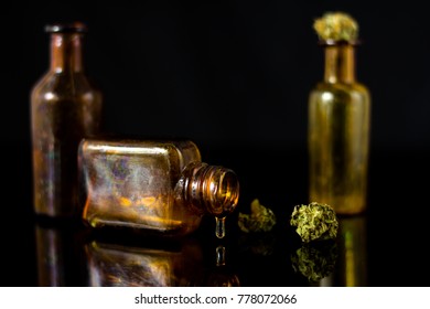 Drop Of Cannabis Oil In Old Apothecary Jar - Resin Marijuana On Black Mirror Background.