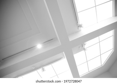 Drop ceiling with frames and panels. Abstract modern business architecture. Interior of commerical real estate. Office building. Regular geometrical background featuring girders and rectangular tiles