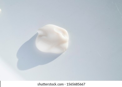 A Drop Of Cream For Body Care, Close-up Detail Of The Beauty Cream Isolated On White Background In Bright Sunlight