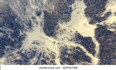 Drop down view of road going through winter forest.