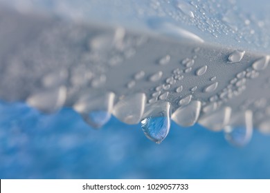 Drop Of Frozen Water Dripping From The Blue Transparency Ceiling
