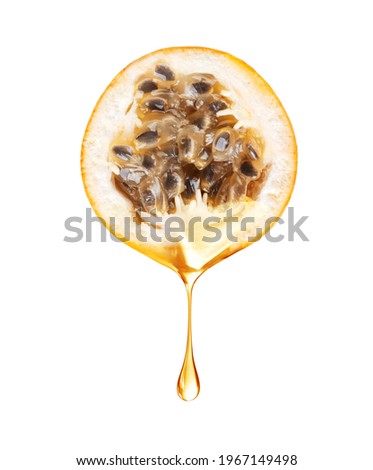 A drop of juice drips from half a passion fruit closeup on a white background
