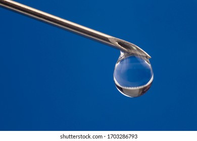 drop of medicine on the tip of a medical injection needle