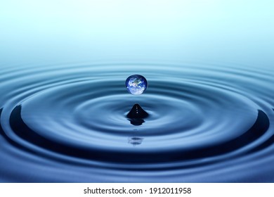 Drop of rain with earth image falling on smooth water surface