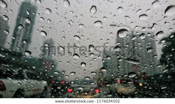 A drop of rain on the car window. Rain water\
falling on the background of a glass surface, Abstract background.\
Selective focus. 