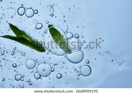 A drop of serum with bubbles and a green leaf on a blue background.