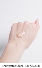 Drop Of Transparent Face Gel On The Girl's Hand On A White Background