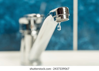 A drop of water drips from a leaky faucet. - Powered by Shutterstock