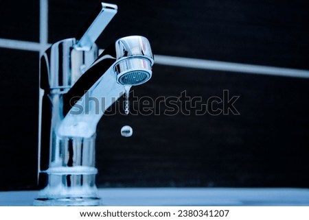 Drop of water from a leaky faucet close-up