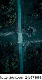 A dropdown view of a bridge with a stream going under it