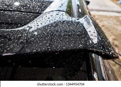 Droplet on the car spoiler & windshield. Water beading after car wash or rain on shiny black
 paint surface. Hydrophobic effect created by ceramic coat or paint sealant . Water drop Backgroud.