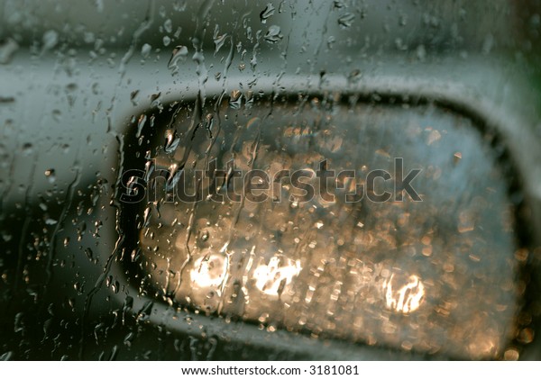 Droplets and car lights reflections through foggy\
car window and rear view\
mirror