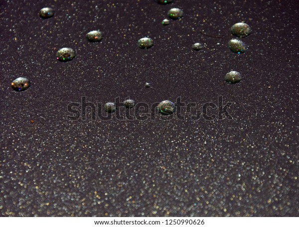 droplets of water on a silver mirror surface. no\
fixed focus.