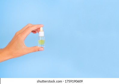 Dropper Bottle Mockup. Yellow Cosmetic Oil In A Clear Jar. The Feminine Hand Holds A Jar. Banner Beauty Concept With Copy Space