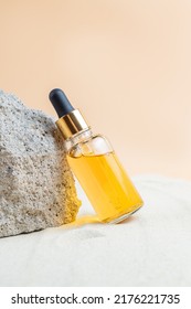 Dropper Bottle Of Moisturizer, Serum Or Vitamin C Oil For Face On Stones With Sand, Sand Background, Summer Face Care.