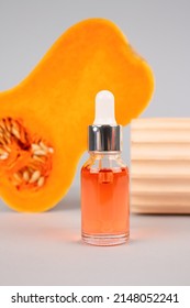 Dropper Bottle Of Natural Organic Cosmetics Oil - Pumpkin Seed Oil Extract For Skincare Or Hair With Pumpkins As Background. Beauty Treatment, Spa Concept, Selective Focus. Vertical Image