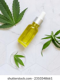 Dropper bottle near green cannabis sativa leaves on a marble table top view. Cosmetic Mockup, Copy space. Organic skincare beauty product. Eco friendly CBD oil - Shutterstock ID 2310348661